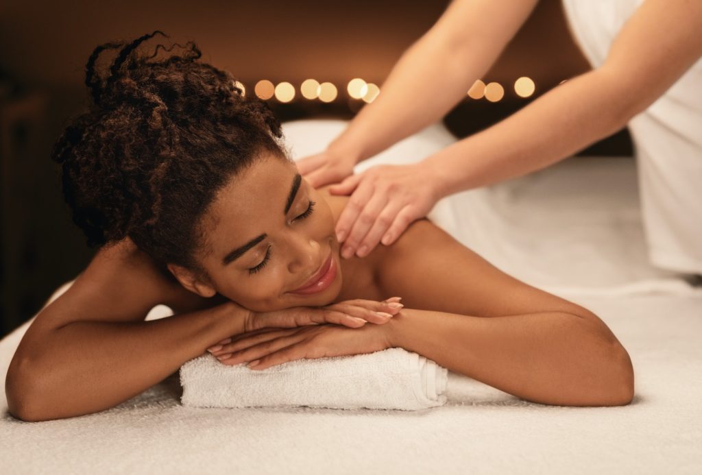 Young black woman getting relaxing massage at spa