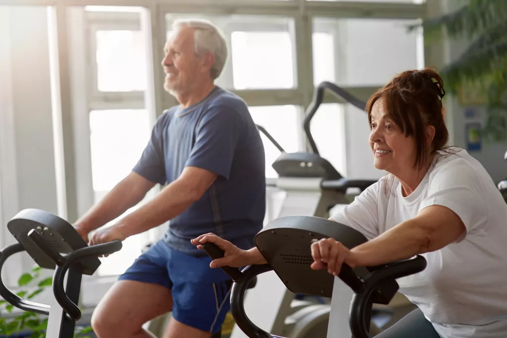 Elderly woman working out in modern gym