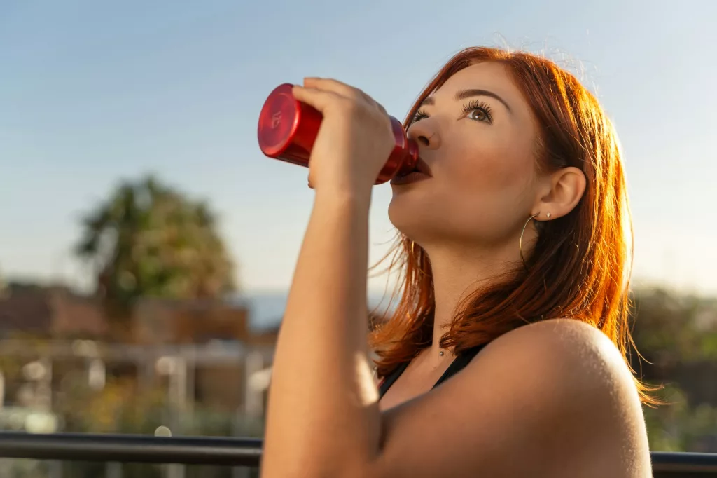 Redhead Woman Hydrating After Workout