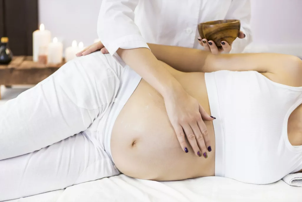 Young pregnant woman have massage treatment at spa