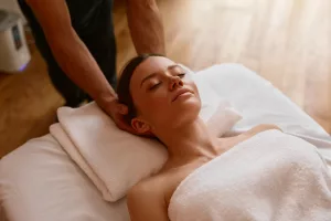 Closeup woman client relaxing under male hands doing head massage