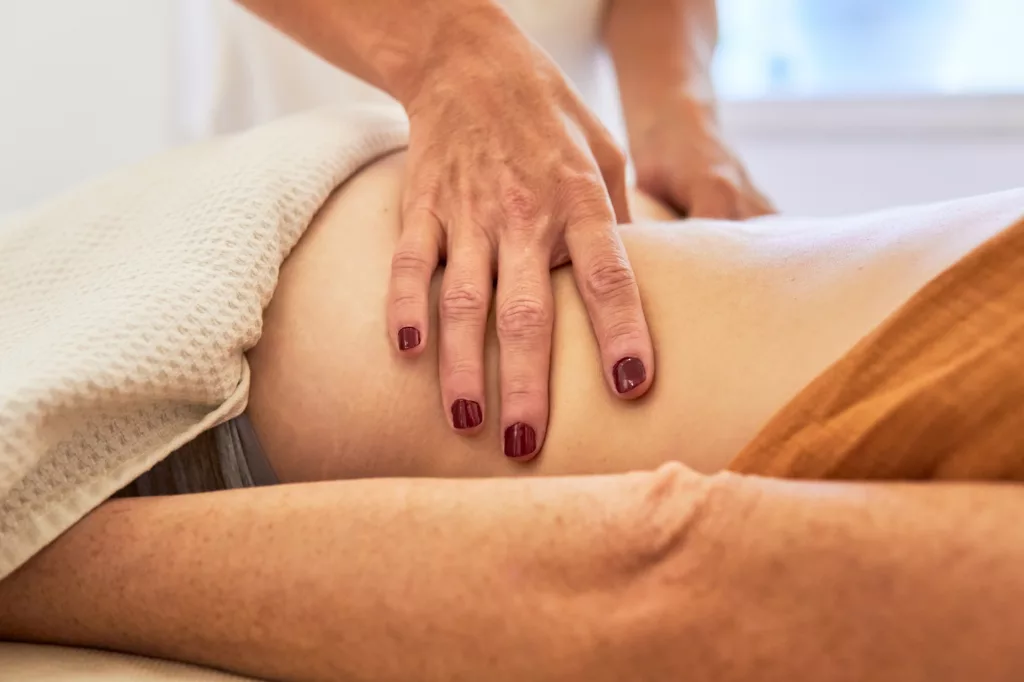 Osteopath massaging woman back to relax muscles and nerves