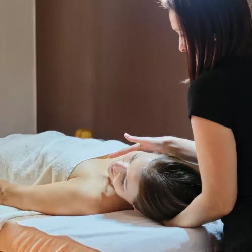 Mature woman lying on massage table and receiving medical massage